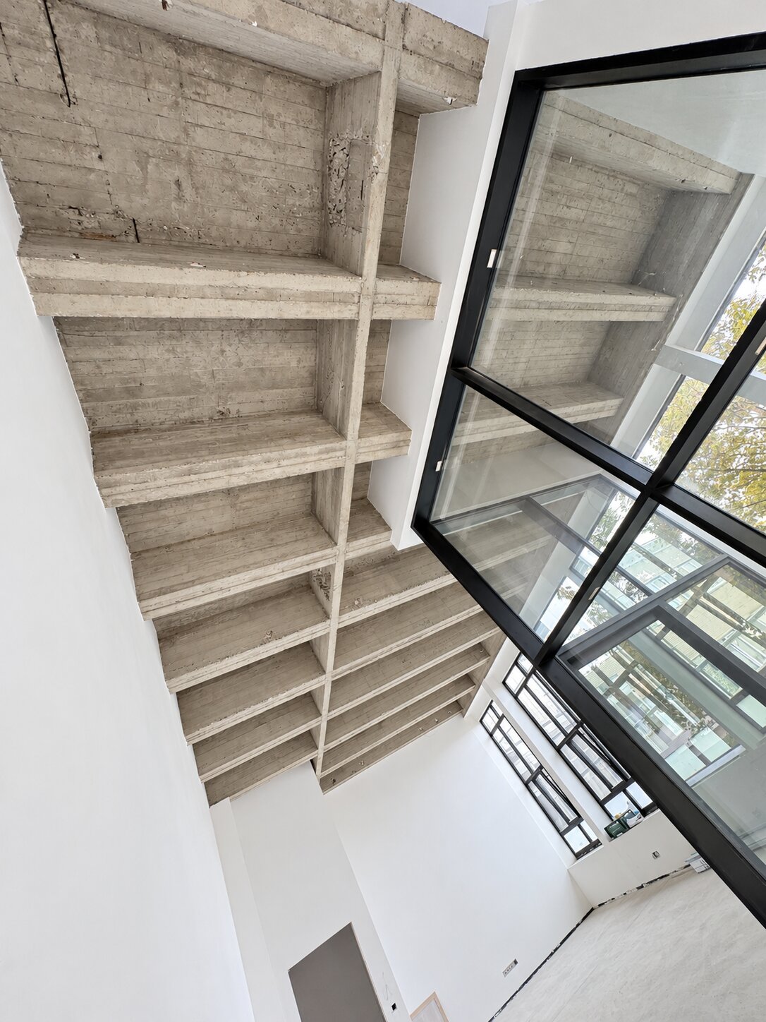 Overzicht van een betonnen plafond met zichtbare balken en bekistingsstructuur.